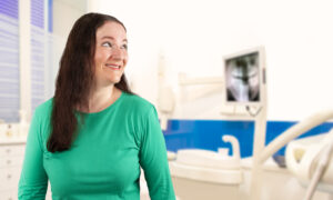 Smiling woman at the dentist's office after treatment